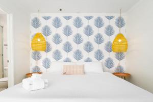 a bedroom with a white bed and a blue and white wall at Sunny on the Ocean - Beachfront- Pacific Beach in San Diego +35 photos