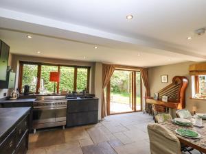 a large kitchen with a stove and a table at Six Acres House in Rye