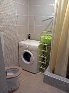 a bathroom with a toilet and a washing machine at Studio apartment Novi Sad in Novi Sad