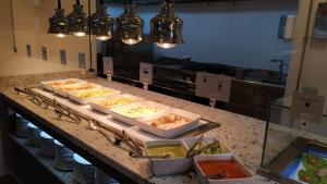 un comptoir de cuisine avec plusieurs plateaux de nourriture dans l'établissement Grupotel Flamingo Beach, à Playa Blanca