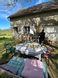 a table and chairs in front of a stone house at Les Ecureuils, chambre au calme in Bussy-la-Pesle +8 photos