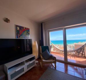 阿爾布費拉的住宿－Varanda do Farol，带电视的客厅,享有海景。