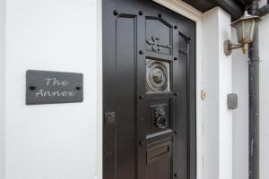 a black door on a building with a sign on it at Annex by the Sea in Lancing