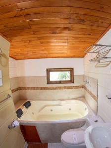 a bathroom with a tub and a toilet and a sink at Hotel Calle Principal in Sáchica