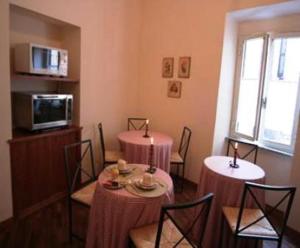 un comedor con 2 mesas y sillas con mantel rosa en B&B Vicolo Vecchio, en Terracina