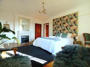 um quarto com uma grande cama branca e uma lareira em Le Manoir du Cerf em Gaillon