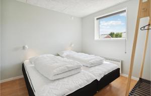 a bedroom with a bed with white sheets and a window at Nice Home In Sydals With Wifi in Neder Lysabild