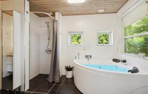 a bathroom with a tub and a shower at 3 Bedroom Nice Home In Sjølund in Sjølund +17 photos