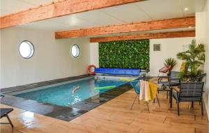 a swimming pool in a living room with a table and chairs at Amazing Home In Le Vieux-bourg With Private Swimming Pool, Can Be Inside Or Outside in Le Vieux-Bourg