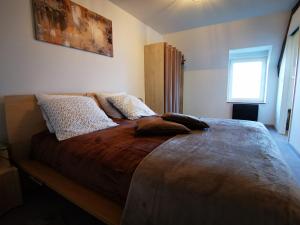 ein Schlafzimmer mit einem großen Bett mit Kissen darauf in der Unterkunft Le Gai Lo Gite in Villers-Pol