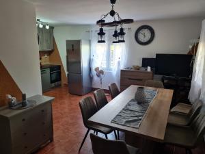 a kitchen and dining room with a table and a clock at Vila Tea Fruska Gora in Čortanovci