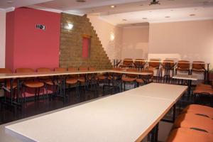 a room with tables and chairs and a brick wall at Hotel Calle Principal in Sáchica