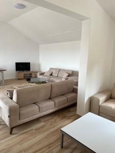un soggiorno con divano e TV di Kalaja Apartment a Prizren