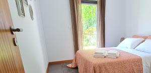 1 dormitorio con 1 cama y 2 toallas plegables. en Quinta Paúl de Baixo en Guimarães