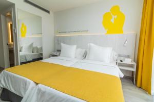 a bedroom with a large bed with a yellow blanket at Lemon & Soul Las Palmas in Las Palmas de Gran Canaria