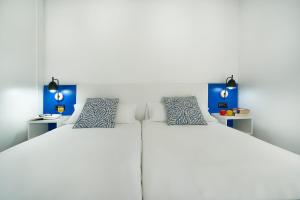 two twin beds in a room with blue accents at Labranda El Dorado in Puerto del Carmen