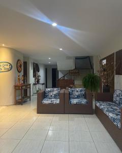 a living room with two couches and a table at Pousada Acácias dos Corais in Cabo de Santo Agostinho