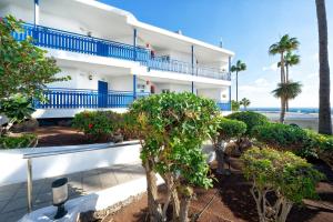 a white building with blue balconies and the beach at BLUESEA El Dorado in Puerto del Carmen