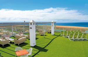 eine Terrasse mit Stühlen und Meerblick im Hintergrund in der Unterkunft FERGUS Cactus Garden in Playa Jandia