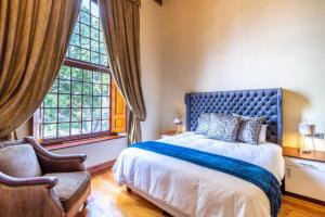 1 dormitorio con 1 cama, 1 silla y 1 ventana en Cape Town Heritage Hotel & Spa en Ciudad del Cabo