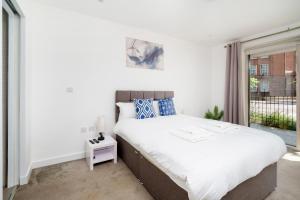 倫敦的住宿－Serene 3BR Family Retreat in Elephant and Castle，一间卧室设有一张大床和一个窗户。