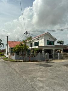 ein weißes Haus mit rotem Dach auf einer Straße in der Unterkunft Eleven8 Taman Pandan in Alor Setar