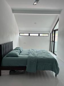 een bed in een witte kamer met een raam bij Eleven8 Taman Pandan in Alor Setar