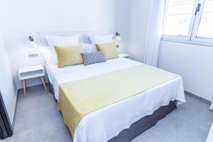 Una cama blanca en una habitación con ventana. en Bex Holiday Homes, en Las Palmas de Gran Canaria