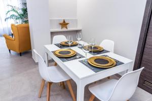 un comedor blanco con una mesa blanca y sillas blancas en Bex Holiday Homes, en Las Palmas de Gran Canaria