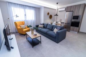 Una sala de estar con un sofá azul y sillas amarillas. en Bex Holiday Homes, en Las Palmas de Gran Canaria