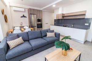Una sala de estar con un sofá azul y una mesa. en Bex Holiday Homes, en Las Palmas de Gran Canaria 38 fotos más