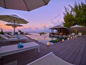 a resort with a pool and tables and umbrellas at Bon Azur Beachfront Suites & Penthouses by LOV in Trou aux Biches