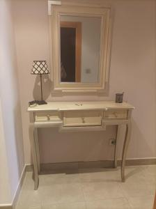 a dressing table with a mirror and a lamp on it at Apartamento A Rapadoira Foz in Foz