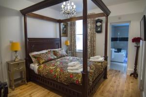 1 dormitorio con cama con dosel y lámpara de araña en Abbey Canterbury en Kent