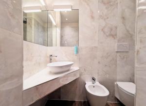 y baño con lavabo, espejo y aseo. en Palazzo Orseolo- Gondola View, en Venecia