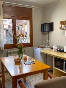 a kitchen with a wooden table with a vase of flowers on it at Estudio Calle Alta in Plan