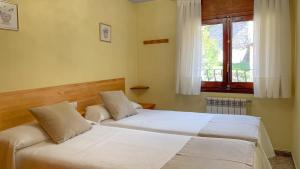 two beds in a bedroom with a window at Estudio Calle Alta in Plan