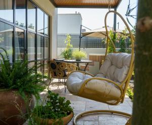 Bustan HaGalil的住宿－גלילה - סוויטת בוטיק רומנטיות לזוגות עם האט טאב פרטי ליד הים，一个带椅子和桌子的庭院,以及一些植物