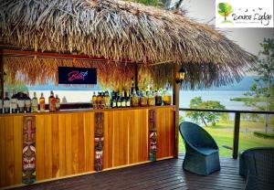 um bar com um telhado de palha num deque em Sauce Lodge - Laguna Azul em Sauce