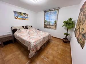 ein Schlafzimmer mit einem Bett und einer Topfpflanze in der Unterkunft Apartamento las Palmeras in Roses