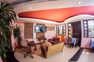- un salon doté de plafonds et de meubles orange dans l'établissement Hotel Calle Principal, à Sáchica