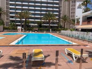 basen z 2 leżakami i budynek w obiekcie Danubio Studio Playa del Inglés w mieście Maspalomas