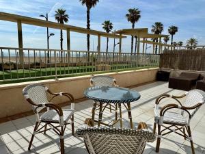 a patio with a table and chairs on a balcony at Reinapart Patacona Beachfront Seaview in Valencia