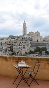 a table and two chairs on a balcony with a city at Antica Dimora Storica La Finestra Sul Campanile in Matera