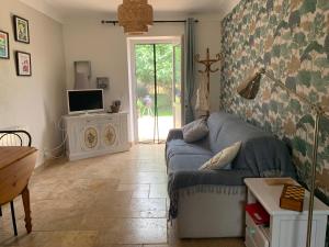 ein Wohnzimmer mit einem blauen Sofa und einem TV in der Unterkunft gîte La Longère bleue in Caylus
