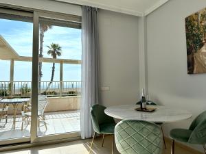 a living room with a table and chairs and a balcony at Reinapart Patacona Beachfront Seaview in Valencia