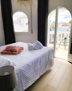 um quarto com uma cama branca e toalhas em Casa Serenity au canal avec piscine et amarre em Empuriabrava