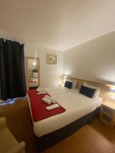 a bedroom with a large bed with towels on it at Budget Hotel Melun Sud - Dammarie Les Lys in Dammarie-lès-Lys