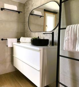 a bathroom with a sink and a mirror at Casa Serenity au canal avec piscine et amarre in Empuriabrava