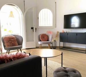 a living room with two chairs and a tv at Casa Serenity au canal avec piscine et amarre in Empuriabrava